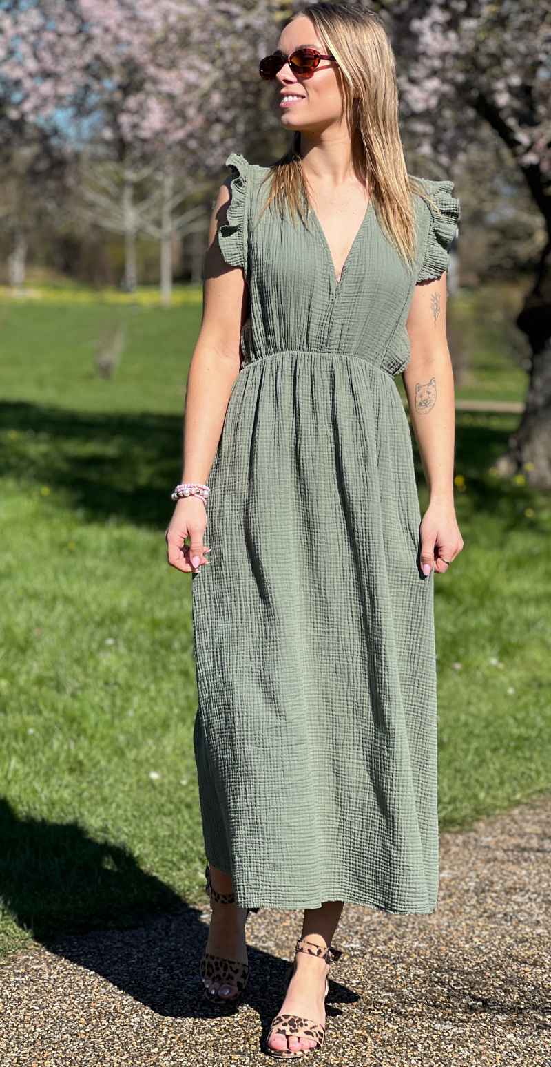 Lang, lys olivengrøn kjole i tekstureret gaze-stof - V-hals, flæseærmer, markeret talje og ankellængde - let, crinklet struktur og elegant sommerlook, forhandles hos LikeLondon.