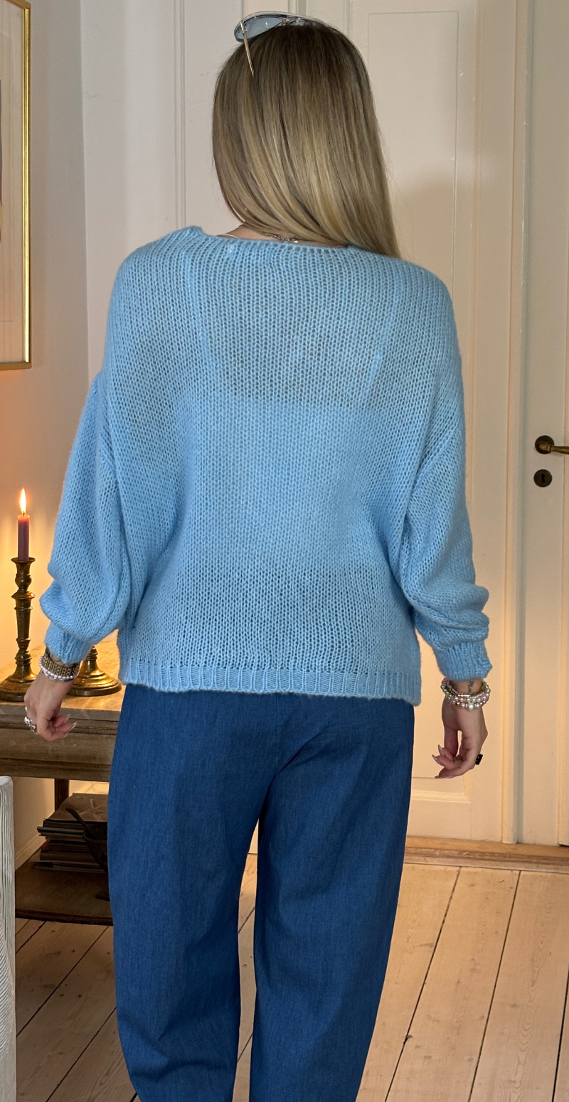 Zinka strik med lange ærmer og knude foran sky LikeLondon