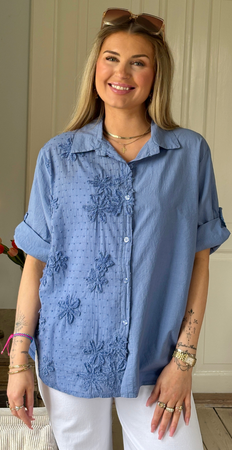 Sigga skjorte med broderi og blomst i den ene side denimblå Likelondon