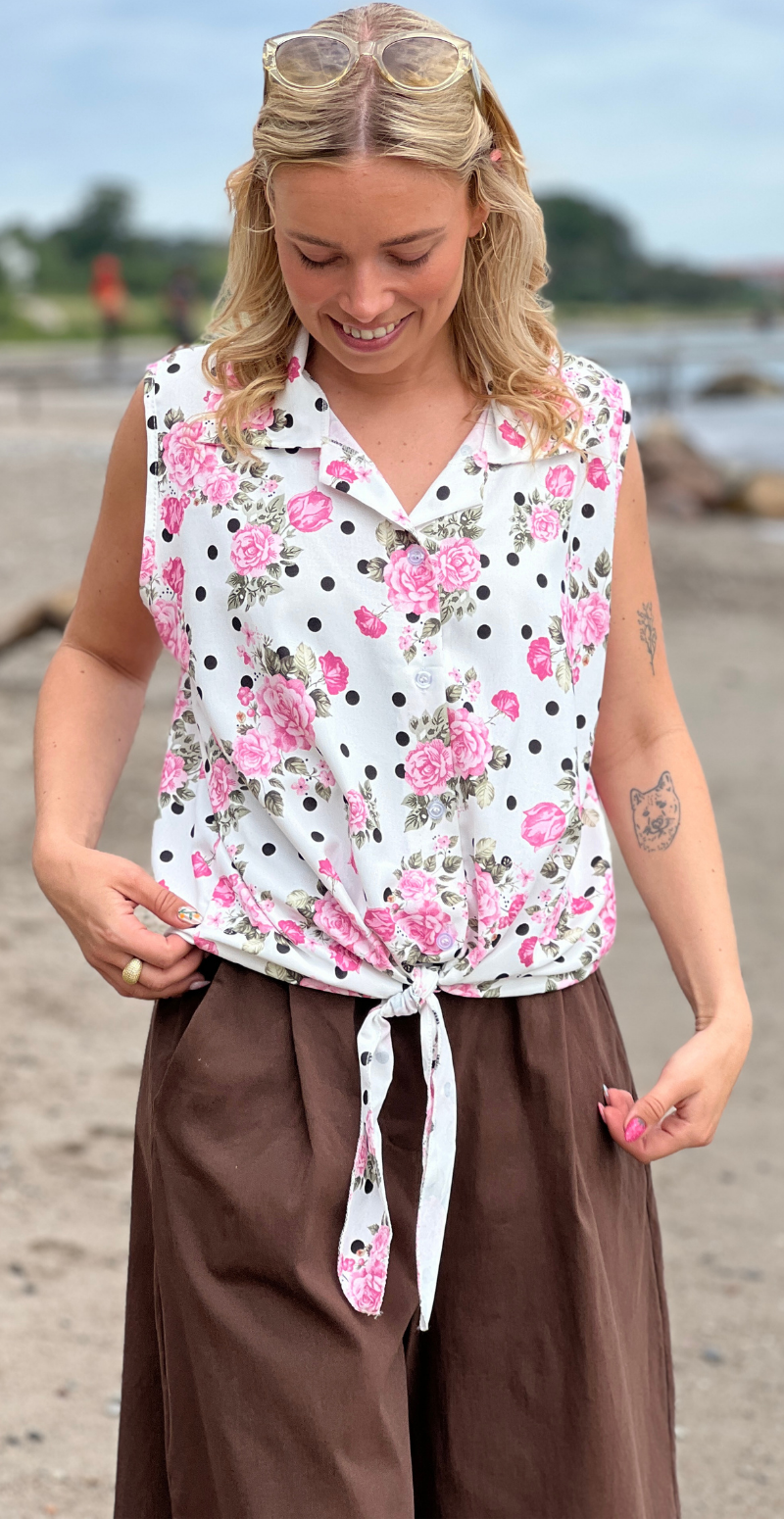 Ulla blomstret top med knapper og bindedetalje foran pink LikeLondon