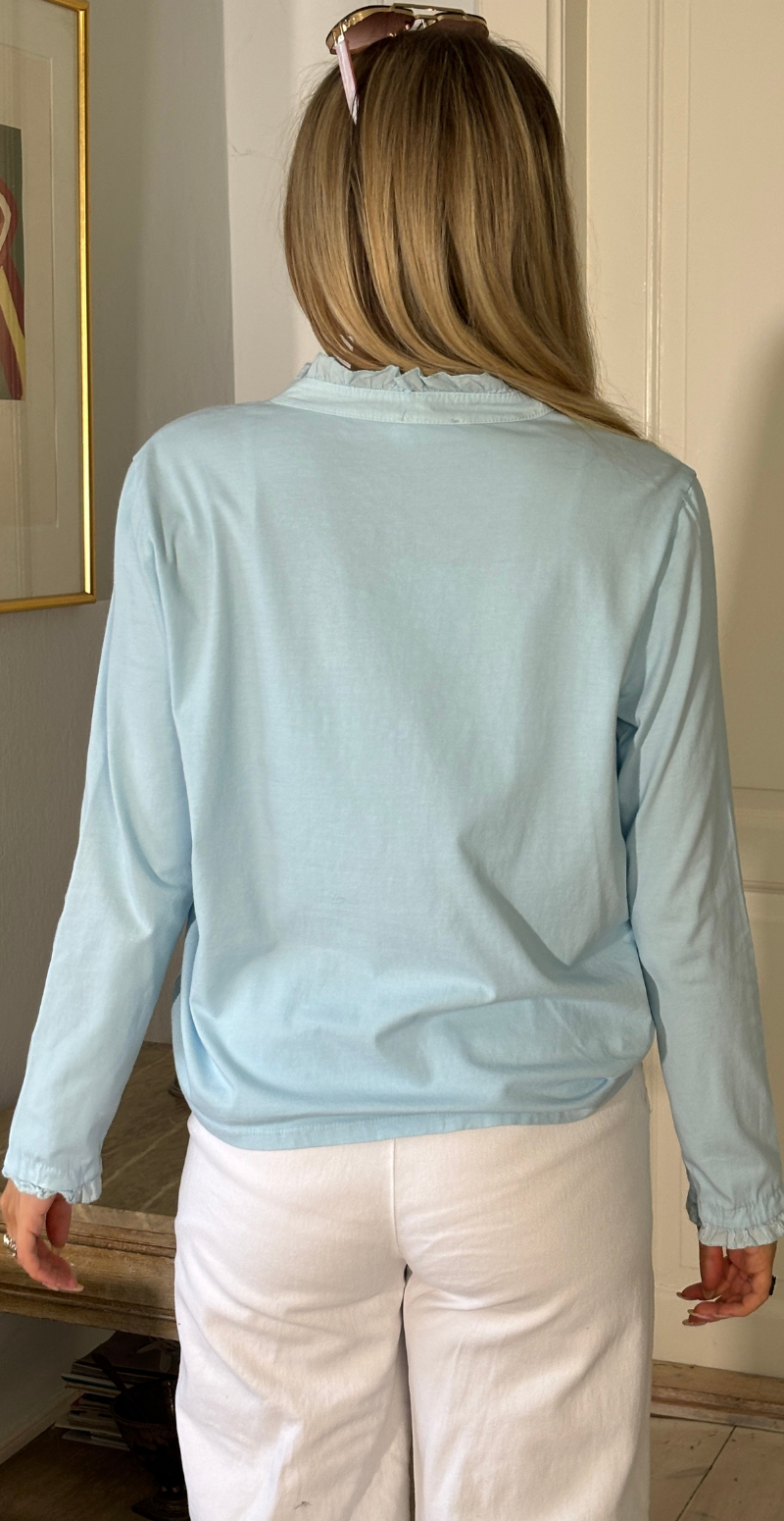 Alpha bluse med stolpelukning og flæsedetaljer lysblå LikeLondon