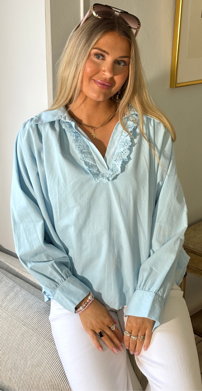 Otella fløjlsbluse med v-hals og flæsekant lysblå LikeLondon