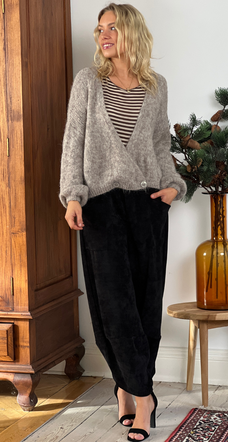 Kvinde i taupefarvet Kitty strikcardigan med wrapeffekt og knapper forfra.