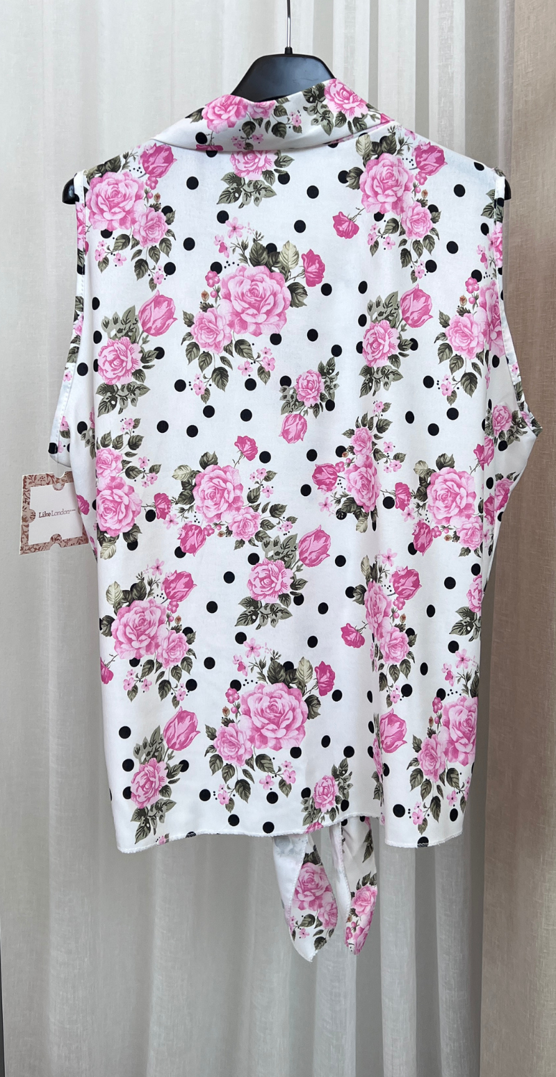 Ulla blomstret top med knapper og bindedetalje foran pink LikeLondon