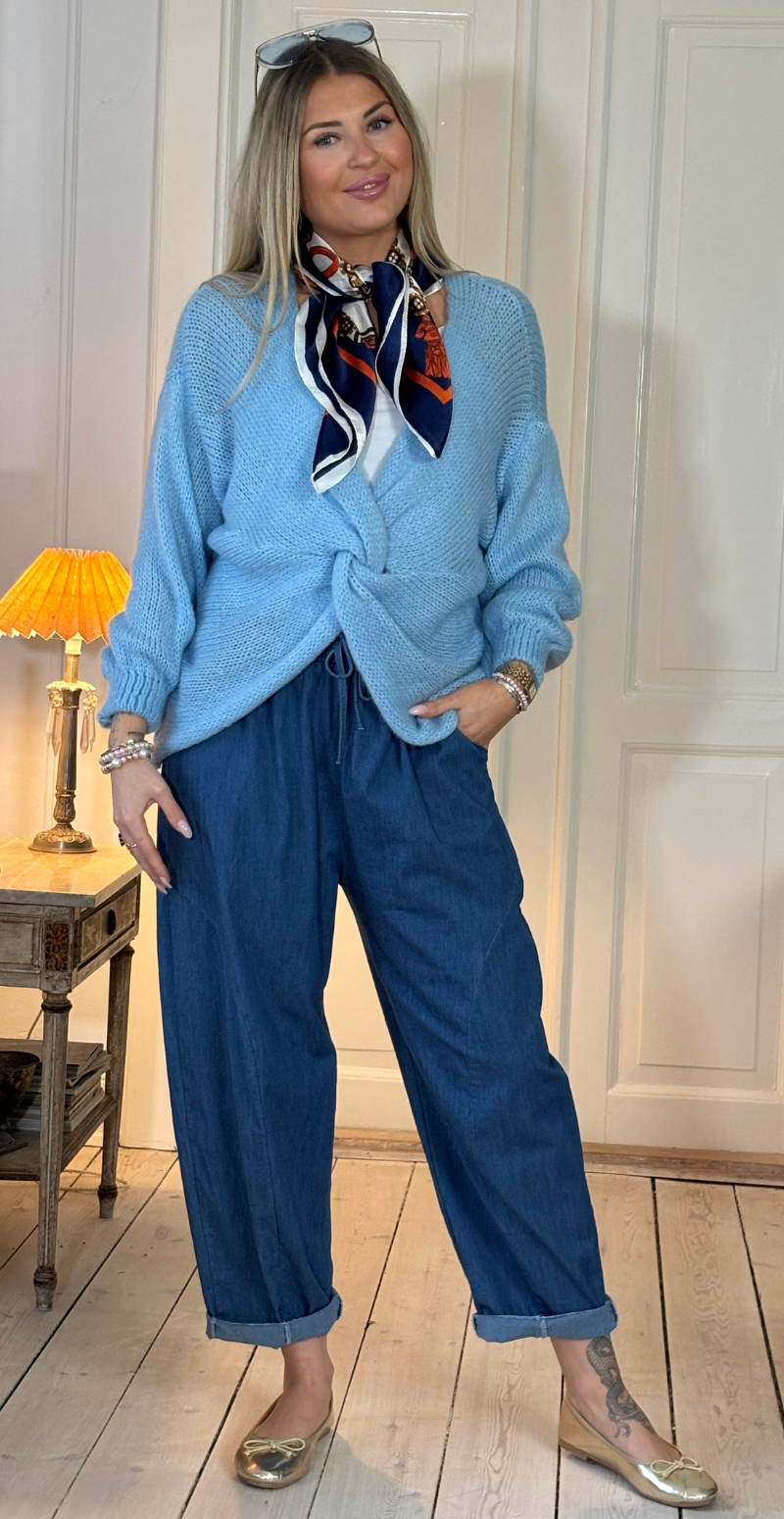 Zinka strik med lange ærmer og knude foran sky LikeLondon