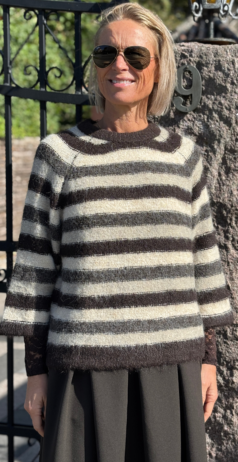Kvinde i Lulu pullover med brune og beige striber og 3/4 ærmer set forfra.