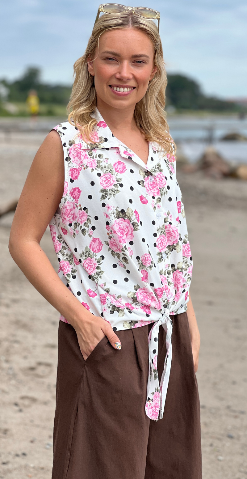 Ulla blomstret top med knapper og bindedetalje foran pink LikeLondon
