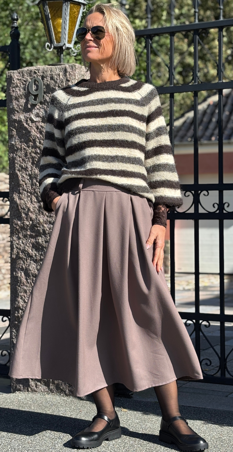 Kvinde set forfra iført stribet Lulu pullover i mole melange og brun nederdel.