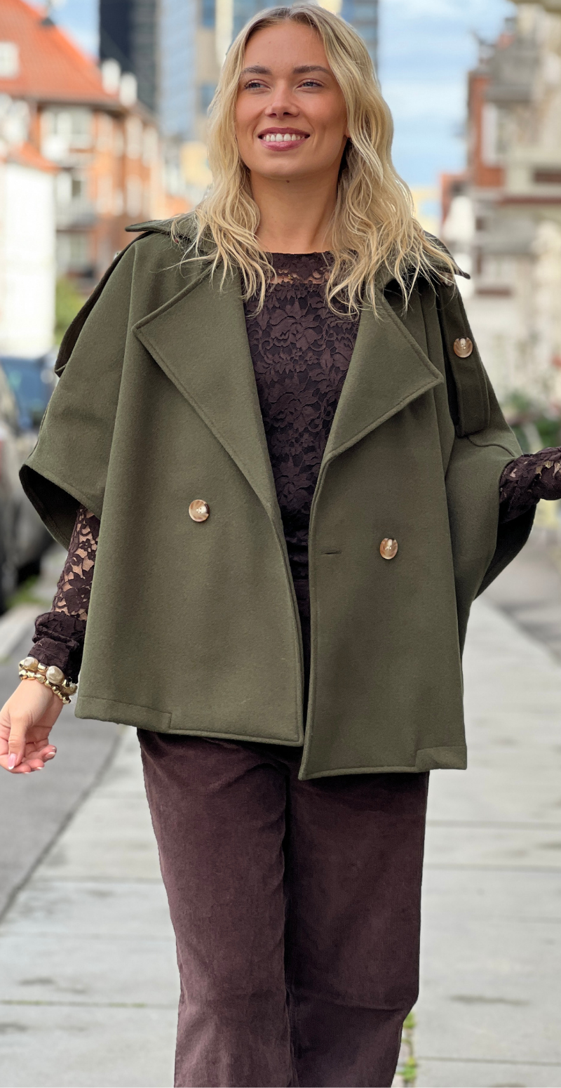Kvinde i olivengrøn Cleo kort poncho jakke med knapper forfra fra LikeLondon.com