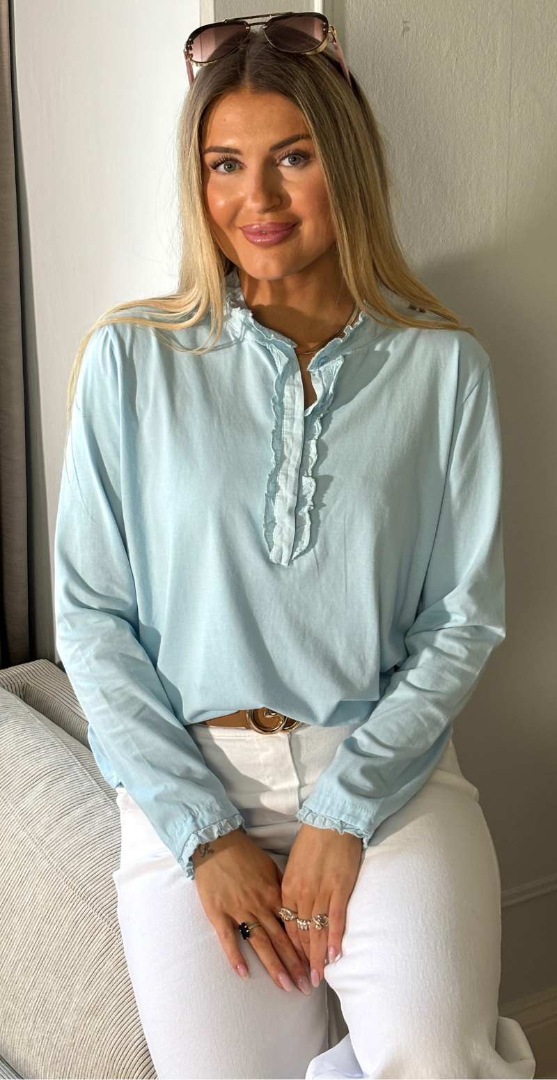 Alpha bluse med stolpelukning og flæsedetaljer lysblå LikeLondon