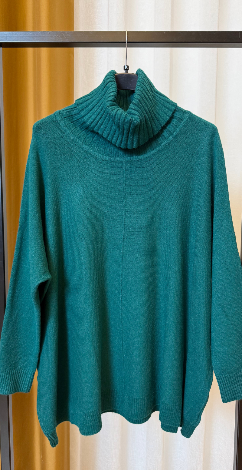 Metha strik med rullekrave og vidde og syning foran grøn LikeLondon